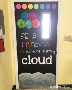 a classroom door decorated with the words, be a rainbow in someone else's cloud