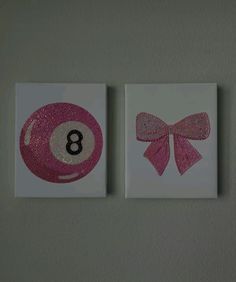 two pink and white cards with the number eight ball on them are hanging on a wall