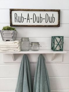 a shelf with towels and jars on it next to a sign that says outhouse