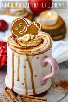 a cup filled with hot chocolate covered in icing and topped with a pretzel