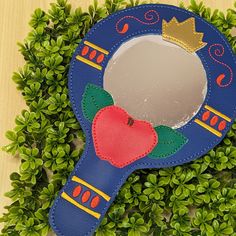 a blue mirror with an apple and crown on it