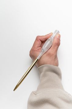 a person holding a pen in their left hand and pointing it at the other side