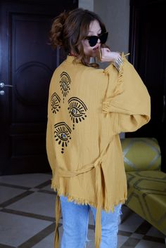 "Beautiful handmade short yellow kimono robe, designed with cotton muslin fabric, it flows as you move for a comfortable wear. Beach cover up, a kimono with evil eyes at the back. This is a lovely, good-quality kimono, with traditional breathable kimono sleeves.        A belt that ties around the waist. Great to wear around the house, on beaches, or to dress up with some jeans & a T-shirt, covering up on the beach with a swimsuit.         We love kimonos as they are so versatile. They also make really special & unique birthday, valentines Day, Christmas gifts, and Mother's Day gifts. The perfect combination of comfort and style, this kimono is a great addition to your new season wardrobe.    Cotton Fabric and Handmade      Length from shoulder: 75 CM Width: 130 CM Kimono Size: One/Standard Yellow Evil Eye, Festival Kimono, Yellow Kimono, Kimono Dressing Gown, Evil Eyes, Kimono Sleeves, Short Kimono, Muslin Fabric, Cotton Muslin