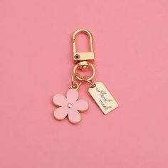 a keychain with a flower on it and a tag hanging from the end