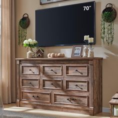 a large tv mounted to the side of a wooden dresser