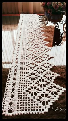 a crocheted table runner is sitting on the floor