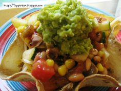 a plate with tortilla shells, guacamole and beans on it