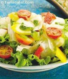 a salad with tomatoes, cucumbers and lettuce on a white plate