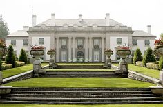 a large white house with lots of flowers on the steps