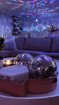 a living room filled with furniture and disco ball decorations on top of a round table