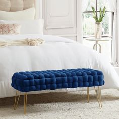 a blue bench sitting on top of a white bed