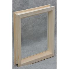 a wooden frame sitting on top of a gray surface with a white wall behind it