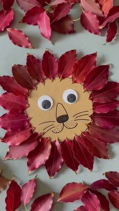 a paper lion made out of leaves with eyes on it's face and nose