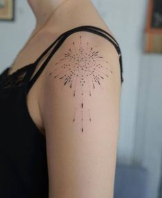 a woman with a tattoo on her arm that has fireworks coming out of the back