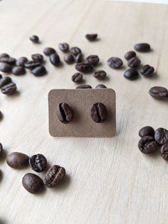 some coffee beans on a wooden table with a square button