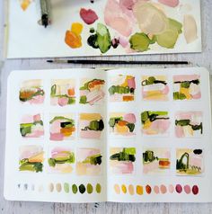 an artist's notebook with watercolors and paintbrushes