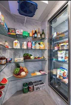 a refrigerator filled with lots of food next to a shelf full of bottles and containers