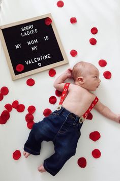 a baby laying on its back next to a sign that says sorry ladies my mom is valentine