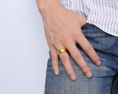 a person wearing a gold ring on their left hand