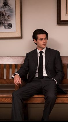 a man in a suit and tie sitting on a bench