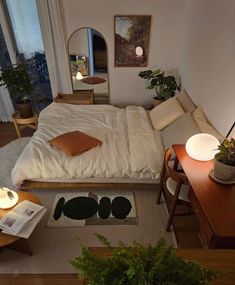 a bed sitting in the middle of a living room next to a window