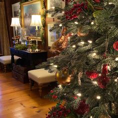 the christmas tree is decorated with red and green ornaments, gold baubles, and other holiday decorations