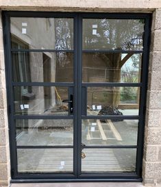 an open window on the side of a brick building with glass panes and metal bars