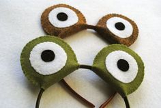 three green and white eyeball headbands on a white surface with black eyes