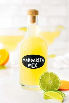 margarita mix in a bottle next to sliced limes