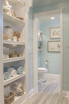 a bathroom with blue walls and white shelves