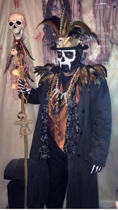 a man dressed up as a skeleton in front of a wall with skulls on it