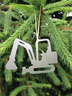 a metal ornament hanging from a christmas tree with a construction vehicle on it