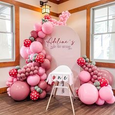 balloon arch with pink and red balloons in front of it