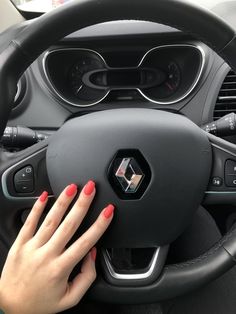 a woman's hand on the steering wheel of a car