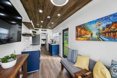 a kitchen and living room are shown in this modern style home with wood flooring