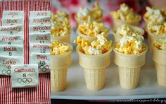 small cones filled with popcorn sitting on top of a white plate