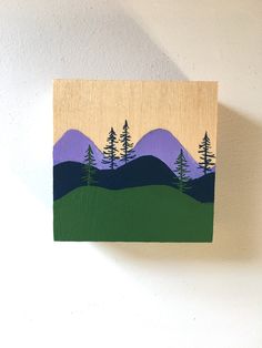 a painting on a wall with trees and mountains painted on it's wood panel