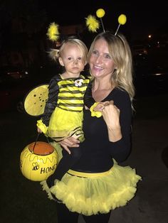 a woman holding a child dressed as a bee