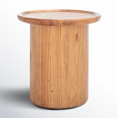 a round wooden table sitting on top of a white floor