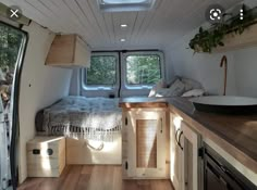 an interior view of a camper with wood flooring and cabinets, including the bed