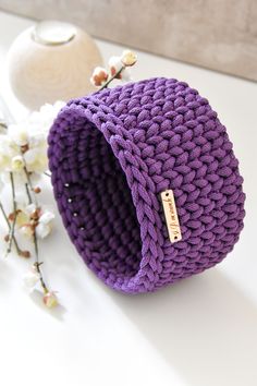 a purple knitted bag sitting on top of a white table