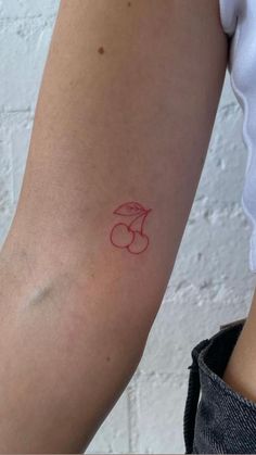 a woman's arm with a red tattoo on the left side of her arm