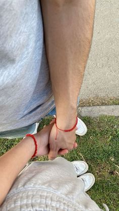 a man holding the hand of a small child in front of him on green grass