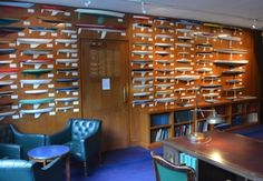 a room with many bookshelves and chairs in it, along with a desk