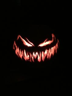 a carved pumpkin is lit up in the dark