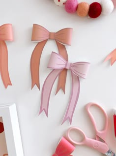 paper bows and other crafting supplies on a white surface with scissors, yarn balls, and thread