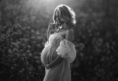 a pregnant woman is standing in a field