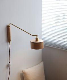 a lamp is on the wall next to a pillow