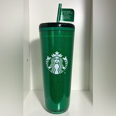 a green starbucks cup with a straw in it