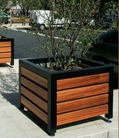 two large wooden planters sitting on the side of a road next to a parking lot